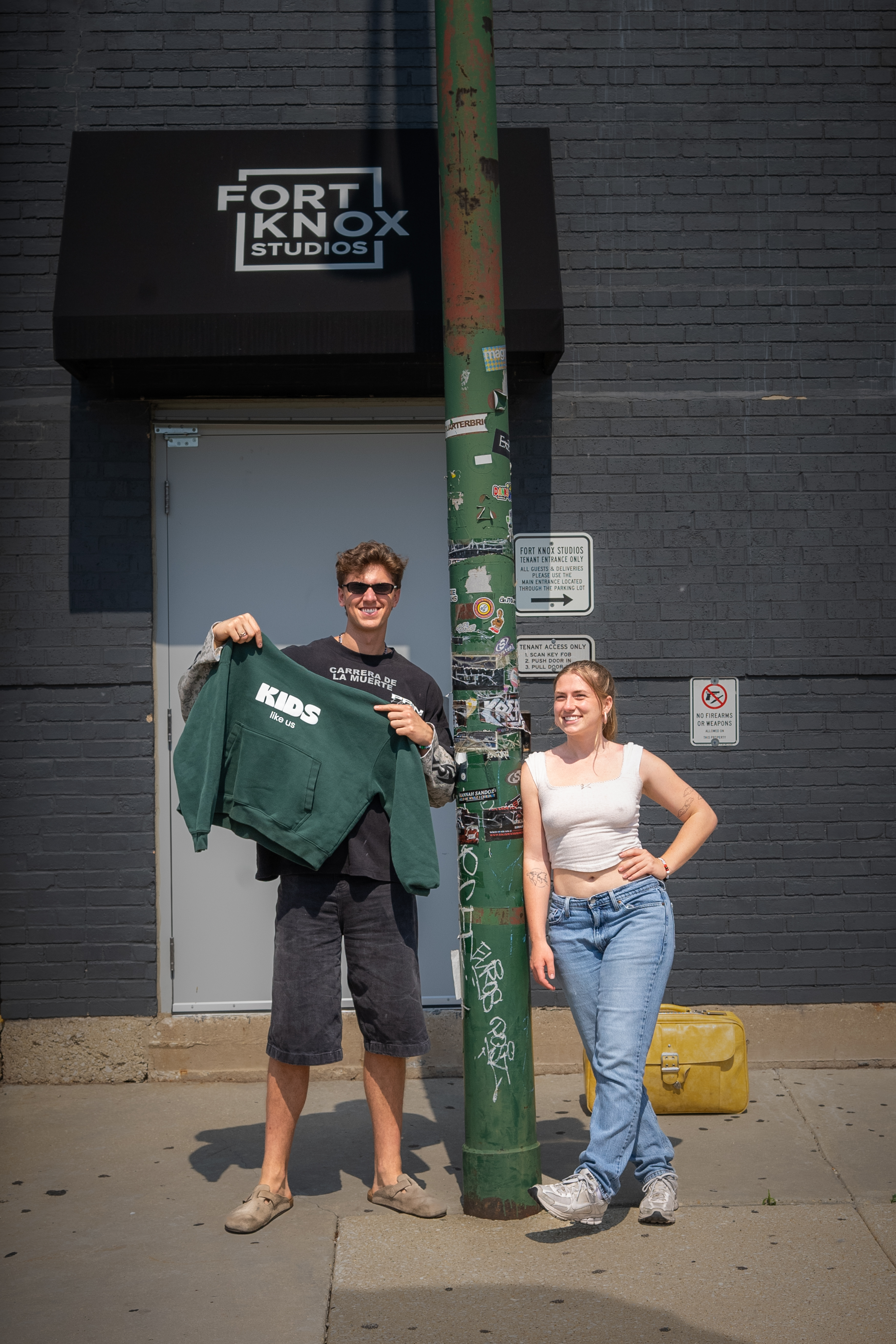 Eddie holds the green KIDS hoodie outside Fort Knox Studios